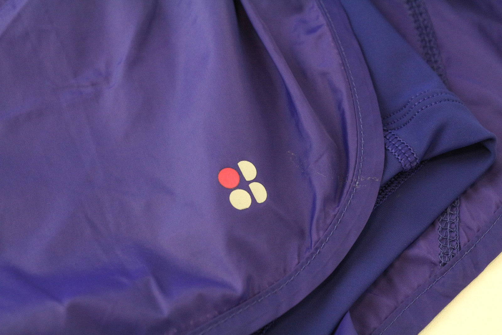 „SWEATY BETTY XS“ violetiniai sportiniai šortai su logotipu. Moteriški daugiasluoksniai sportiniai šortai su užtraukiamu logotipu. 