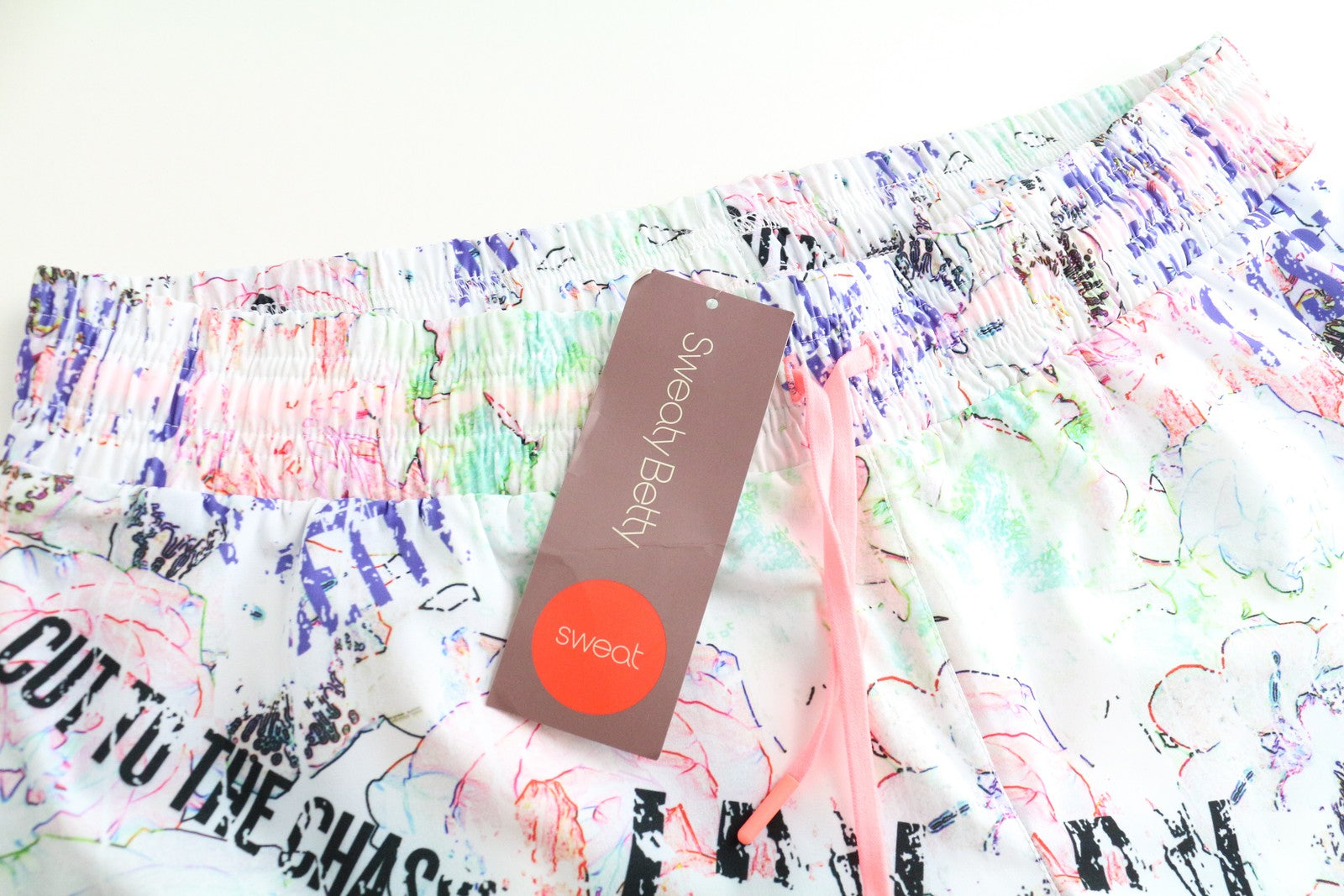 SWEATY BETTY Pas De Chat Dance moteriški šortai XL dydžio, balti, tamprūs, su grafiti raštais 