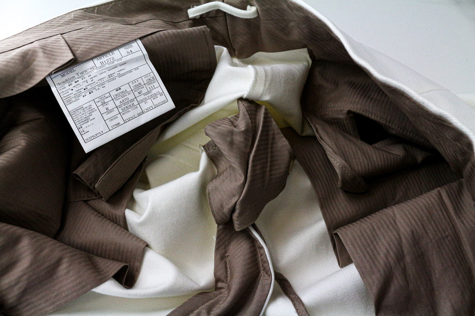 SUITSUPPLY Braddon vyriškos klostuotos kelnės iš UK38R, balkšvos, tamprios medvilnės 