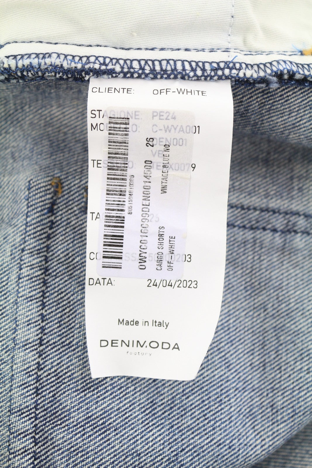 OFF-WHITE moteriški krovininiai šortai W26 džinso mėlynumoje su išblukusia sagomis ir kišenėmis. 